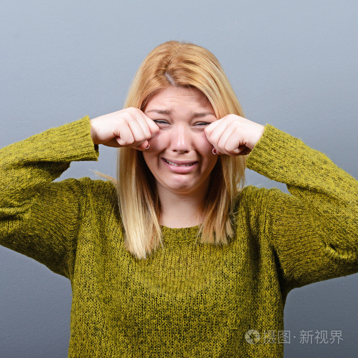 女人哭,擦干眼泪灰色背景