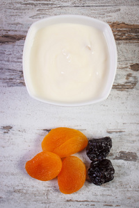 干杏梅和酸奶在碗中增加新陈代谢