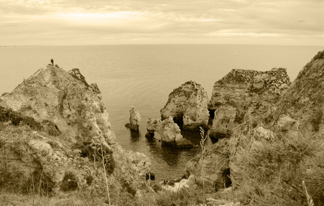 石拱洞穴岩层在多纳安娜海滩拉各斯阿尔加维海岸葡萄牙在傍晚的光线。 旧照片。 萼片