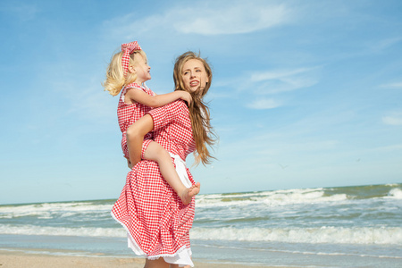 母亲和她的女儿开心玩在沙滩上