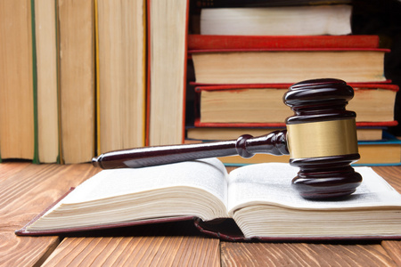 法律书籍与木槌木法官在法庭或法律的执法办公室的桌子上