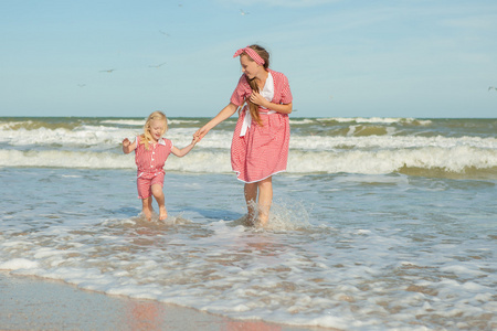 母亲和她的女儿开心玩在沙滩上