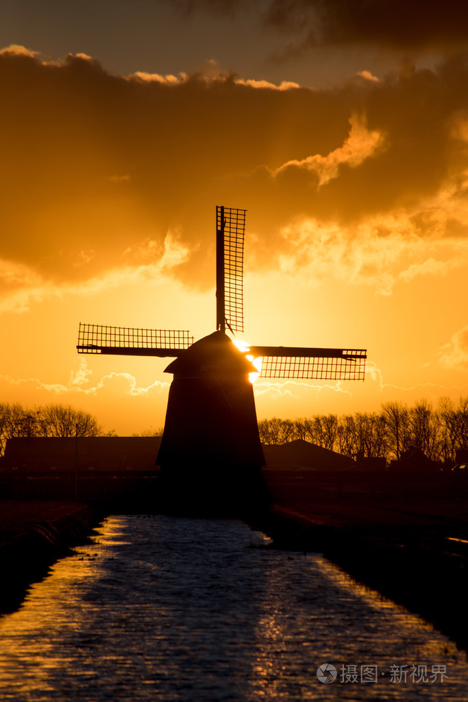 背光荷兰风车日出时