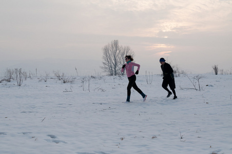男人和女人在雪地上奔跑