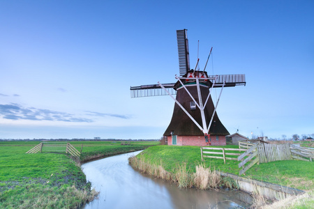 荷兰风车的河流和牧场