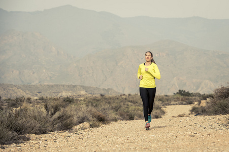 有吸引力的体育女人跑路上地球步道脏与沙漠地带的山风景背景