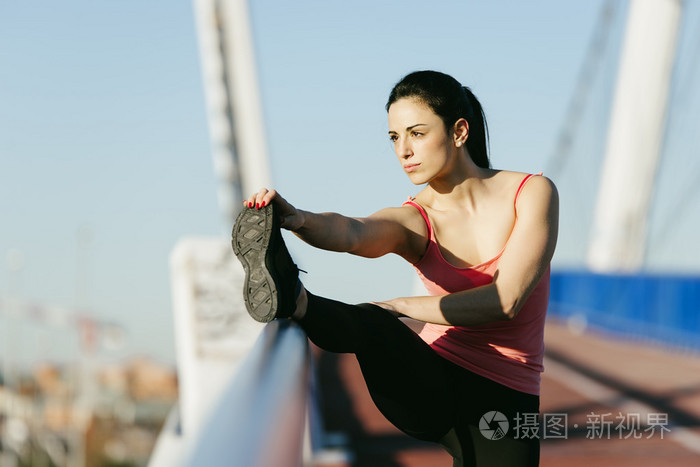 年轻的 fitnesswoman 转轮拉伸腿后运行