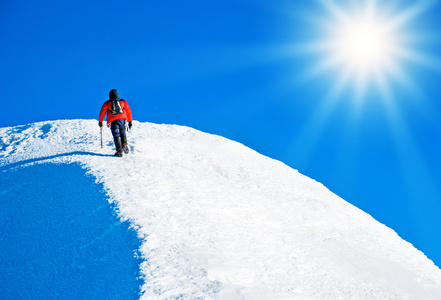 一名登山者攀登顶峰图片