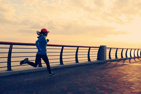 女子赛跑者在日出海边照片