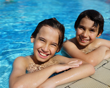 快乐的孩子享受在夏天的游泳池
