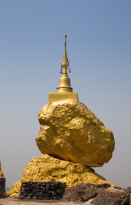 在大石头上的金色佛教宝塔。