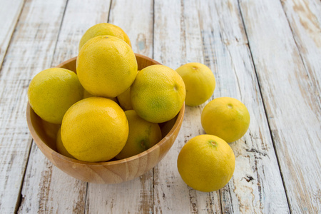 新鲜的柠檬，在一个木碗木背景