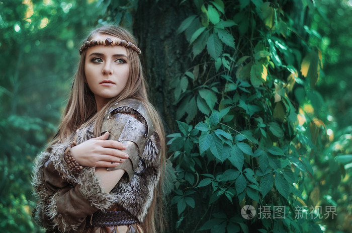 女人猎人手拿弓在森林里. 带弓的亚马逊