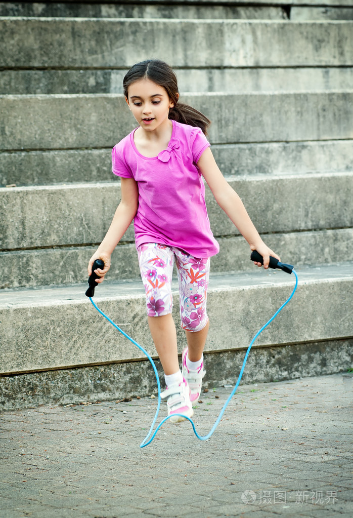 快乐的小女孩在户外跳绳