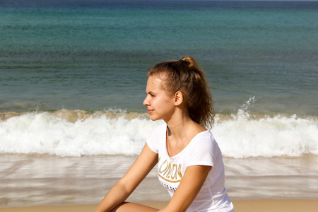 年轻体贴的女孩在海滩上, 看着远处