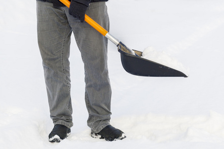 在冬天的 snovy 道路上的雪铲的男人