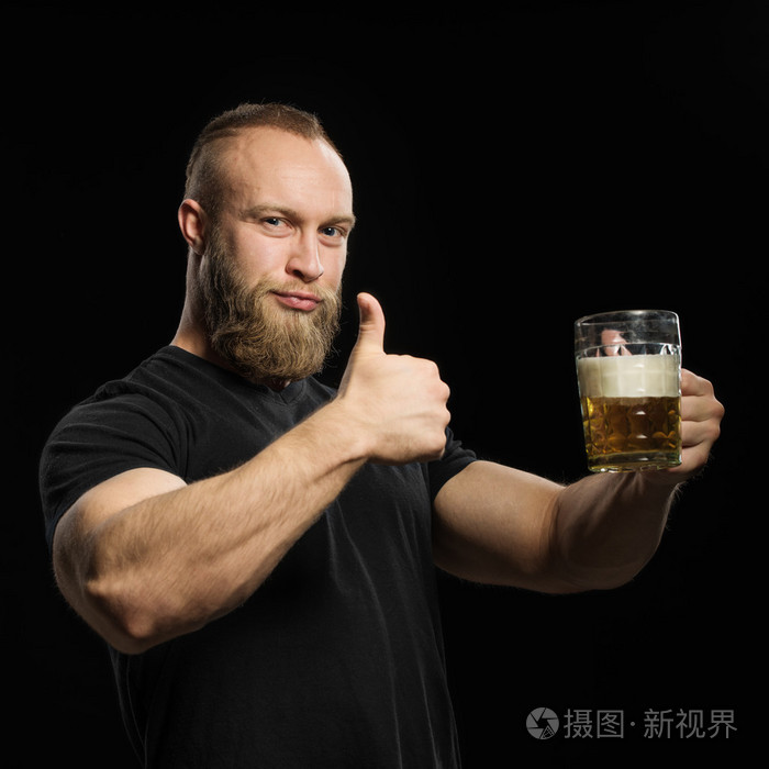 有胡子的人在黑色的背景,从一大杯啤酒喝啤酒