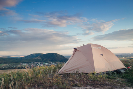 在农村的野营帐篷。夏天，蓝色天空 白云和绿山