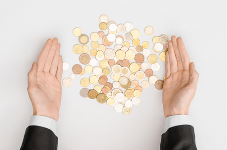 金钱和财务主题 钱硬币和人的手在黑色的西装，在灰色的背景上显示的姿态顶视图