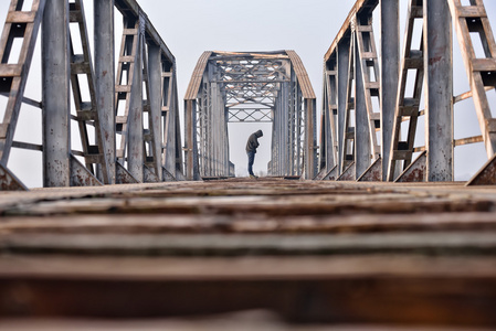 抑郁症在日落的时候坐在桥上,伤心少年照片
