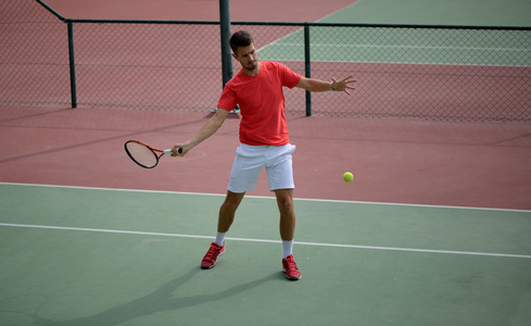 男子网球运动员实践在网球场