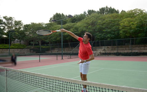 男子网球运动员实践在网球场