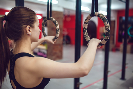 运动的女孩正准备在吊环上的运动照片