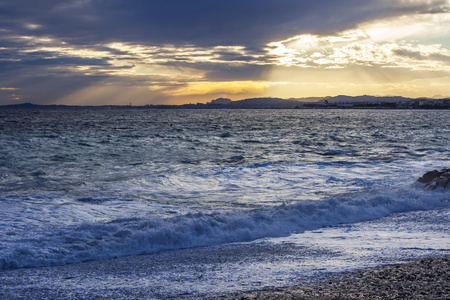 海景观。用梁的日落的太阳点燃的海浪和风暴的波浪线