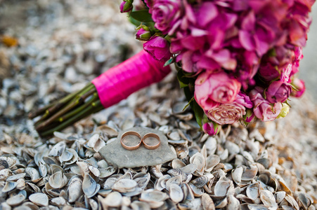 与圆环壳在优雅的粉色婚礼花束