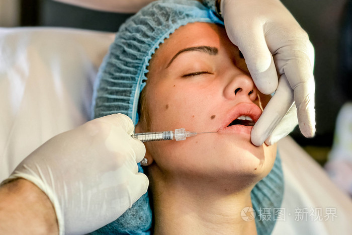 年轻女子在她的嘴唇在美容院获取打针