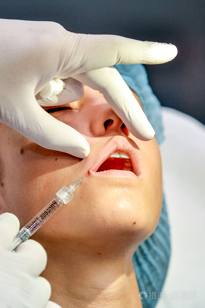 年轻女子在她的嘴唇在美容院获取打针