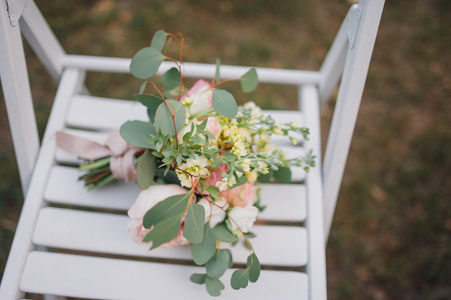 靠近白色木椅上优雅的新娘花束
