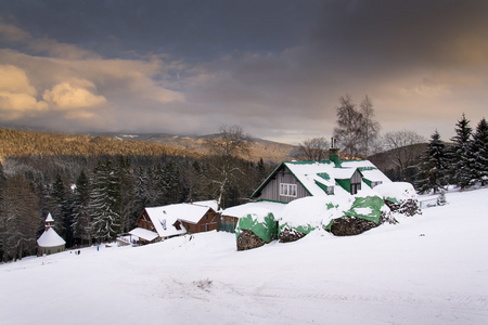 白雪覆盖的房子在日落在霜山国家