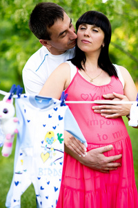 快乐怀孕的妇女和她的丈夫在公园