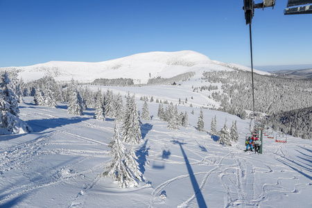 滑雪者在滑雪缆车上可爱的阳光灿烂的日子在喀尔巴阡山脉上