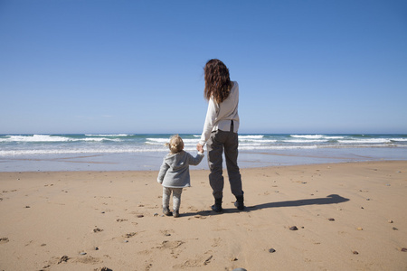 宝宝和妈妈手牵着手在海滩