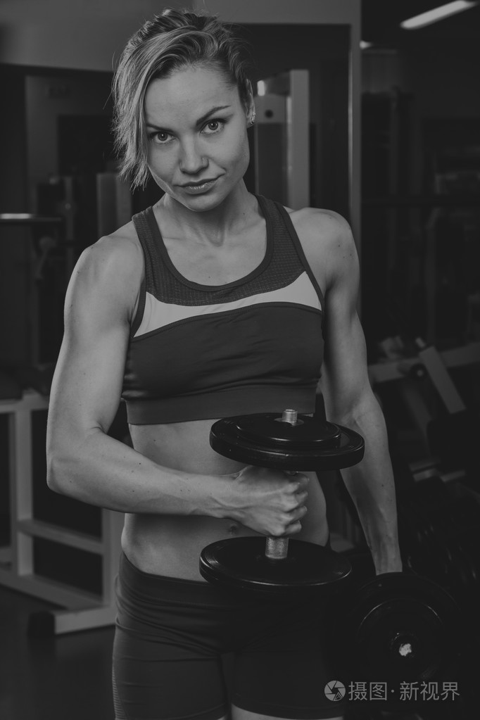 体育的金发美女美丽坚强的女孩bodyfitness女子健身器材在健身房锻炼