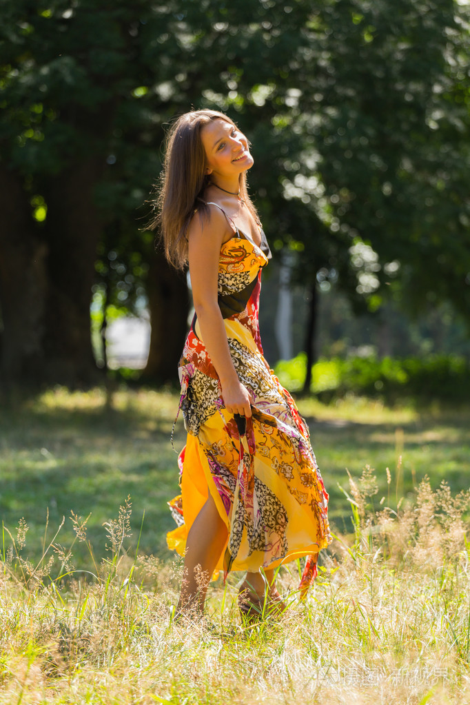 性格开朗的女孩,沐浴在夏日的阳光温暖的阳光.美丽的形象,一个