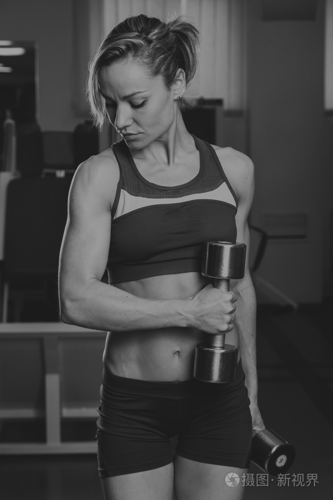 健身房的女人俯卧撑强度伏地挺身用哑铃锻炼在健身锻炼体育锻炼的年轻