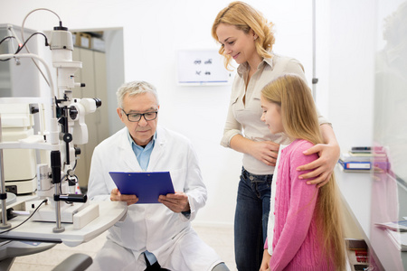 男性的眼科专家给母亲诊断为孩子的视力