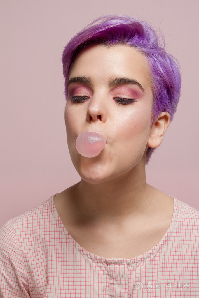 紫罗兰色短头发的女人在粉红色的粉彩粉彩,吹泡泡糖 b