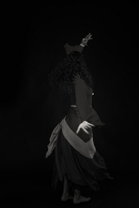 吉普赛人衣服的黑发女郎。传统吉普赛妇女的配件和服装。情绪和吉普赛风味。在黑色背景上的吉普赛人