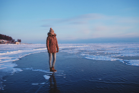 小女孩站在冰封的贝加尔湖的纯冰上照片