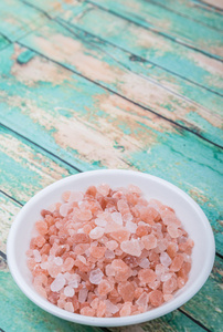 喜马拉雅山岩盐白色碗在木制背景上照片