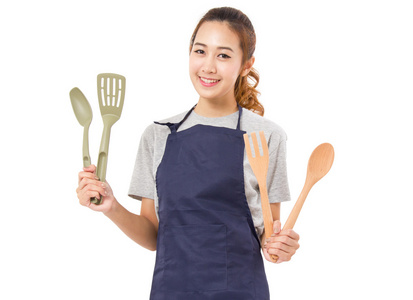 亚洲女人穿着围裙和显示烹饪工具上孤立