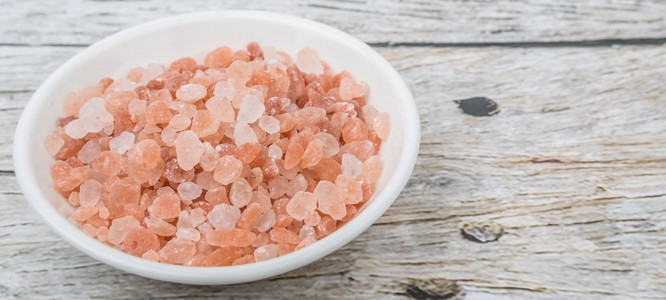 喜马拉雅山岩盐白色碗在木制背景上照片