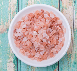 喜马拉雅山岩盐白色碗在木制背景上照片