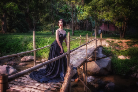亚洲在竹桥上的黑色长礼服优雅女人