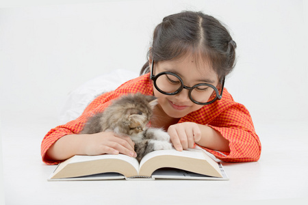 读一本书与可爱的波斯小猫上孤立的小亚洲女孩