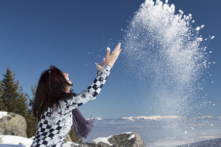 女人扔在冬天的雪在空中